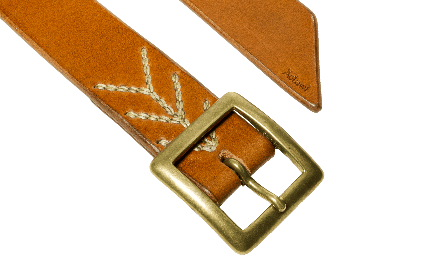 Detail of the buckle and tail of the light brown vegetable tanned leather belt with a square buckle in raw brass, hand-sewn with waxed linen thread